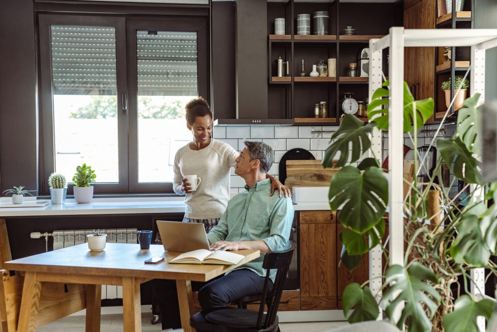 Par på kjøkken, smiler til hverandre